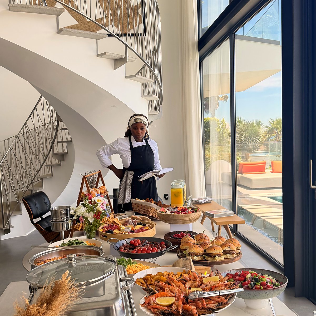 Chefa Jaquelina at a buffet in a villa with a spiral staircase